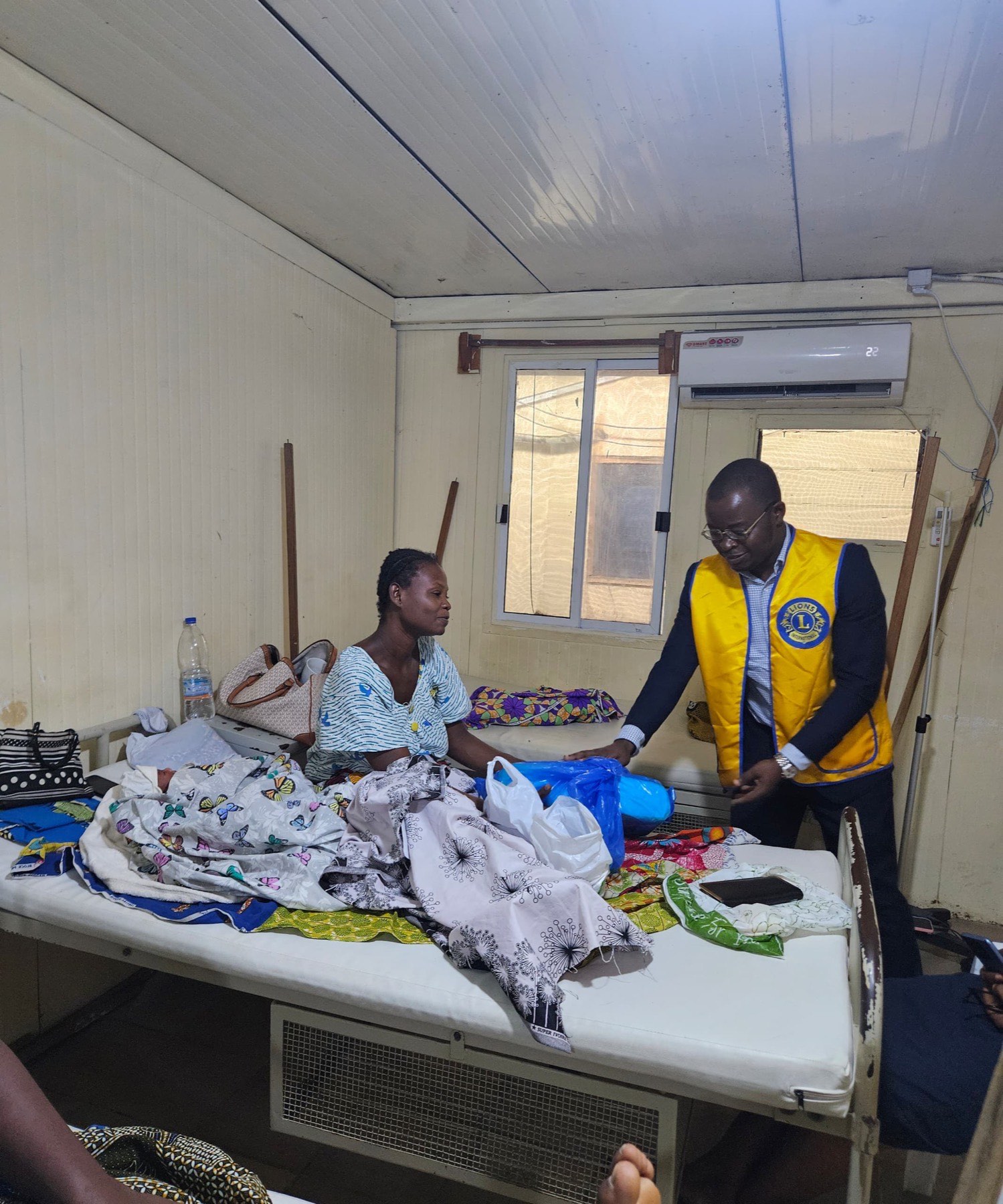 Membre du Lions Club Abidjan Pyramide échangeant avec une jeune maman dans un centre de santé